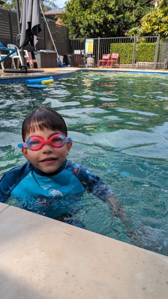 Smiling young swimmer in goggles