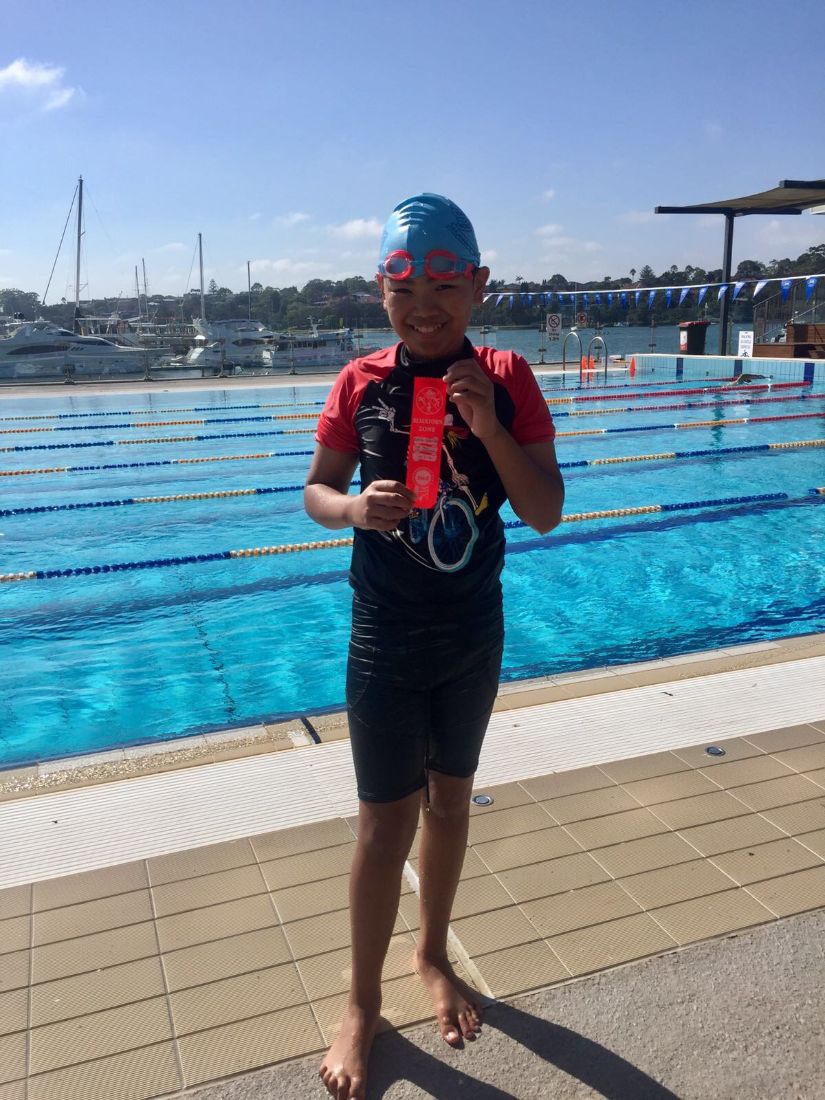 Young swimmer standing poolside